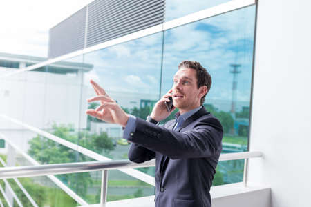 Man beckoning while he is calling on the phoneの写真素材