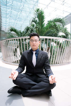 Vietnamese businessman meditating in the officeの写真素材