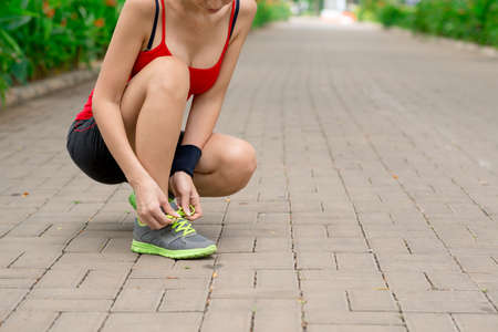 Cropped image of woman tying shoelaces before joggingの写真素材