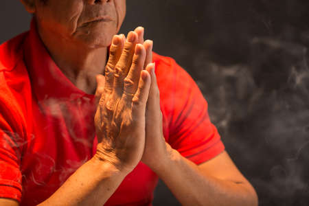 Close-up of mature Buddhist prayingの写真素材