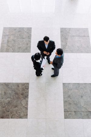 Business people talking in office lobby, view from the topの写真素材