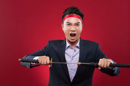 Portrait of businessman with katana sword screamingの写真素材
