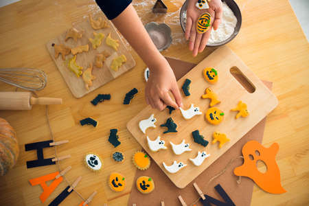 Hands of baker putting decorated cookies on the cutting-boardの写真素材