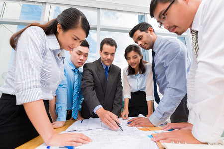 Business team gathered around table to discuss new strategy