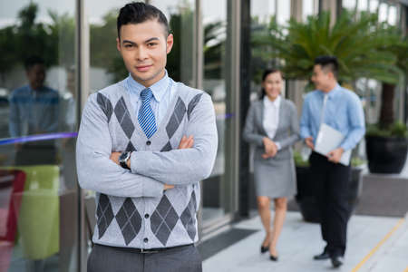 Portrait of confident attractive businessman standing with his arms foldedの写真素材