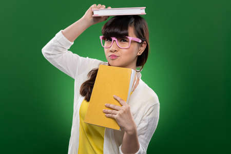 Funny Vietnamese girl holding books and looking at the cameraの写真素材