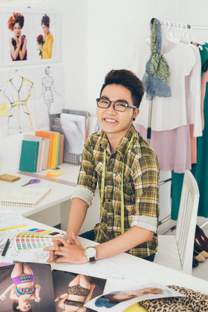 Portrait of happy Asian tailor working in his studio