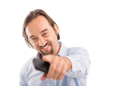 Handsome man holding cellphone and pointing at you