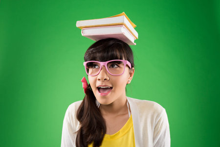Young girl balancing books on head