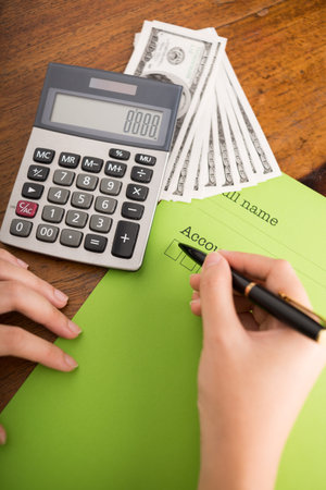 Close-up of bookkeeper counting monthly income and feeling papers