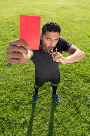 Portrait of referee showing red card as a symbol of dismissalの写真素材