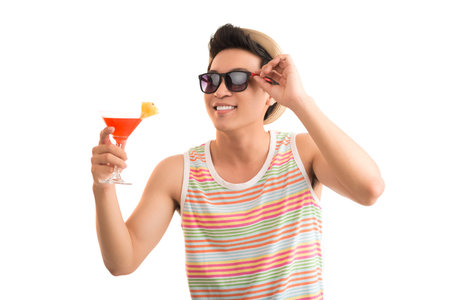 Portrait of cheerful young man in sunglasses with a cocktailの写真素材