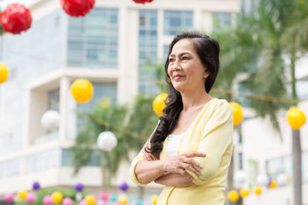 Portrait of senior Vietnamese woman standing outdoorsの写真素材