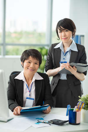 Portrait of two businesswomen looking at camera and smilingの写真素材
