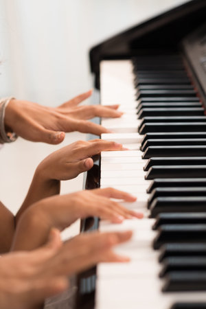 Hands of two people playing the piano, selective focusの写真素材