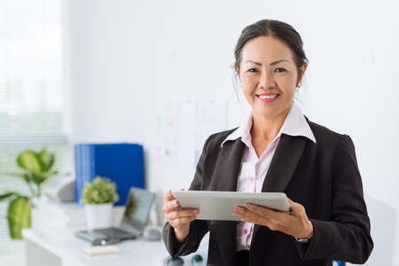 Mature Asian businesswoman holding digital tabletの写真素材