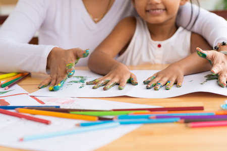Cropped image of mother and daughter doing fingerprints, selective focusの写真素材