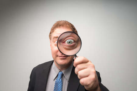 Mature businessman looking through magnifying glassの写真素材