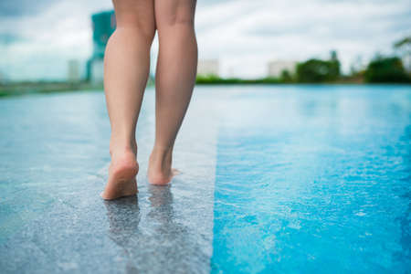 Legs of woman walking along the swimming poolの写真素材