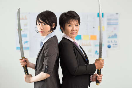 Determinate businesswomen with katanasの写真素材