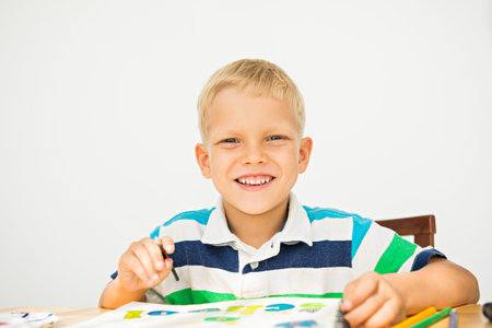 Happy boy drawing at his work place