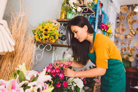 Young florist examining flowers at the shop