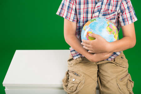 Cropped image of schoolboy with a globe of the worldの写真素材