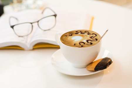 Cup of cappuccino and a biscuitの写真素材