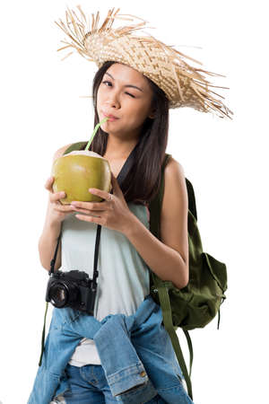 Young Asian traveller drinking milk of green coconutの写真素材