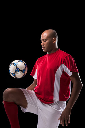 Soccer player kicking ball by kneeの写真素材