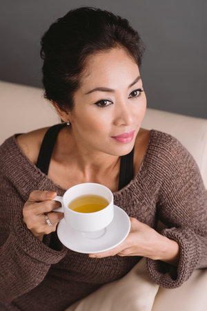 Portrait of gorgeous Vietnamese woman with a cup of green teaの写真素材