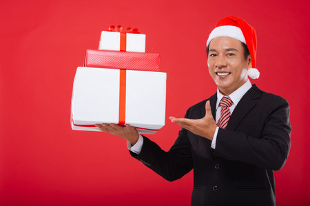 Middle-aged entrepreneur showing a stack of Christmas giftsの写真素材
