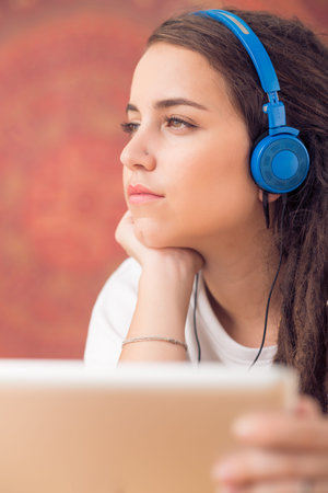 Portrait of young beautiful girl listening to the musicの写真素材