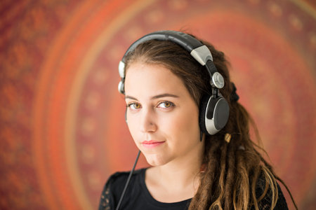 Portrait of pretty girl with dreadlocks listening to the musicの写真素材