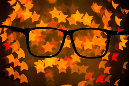 Glasses on the background of Christmas lightsの写真素材