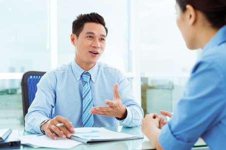 Middle-aged businessman discussing document with his female employeeの写真素材