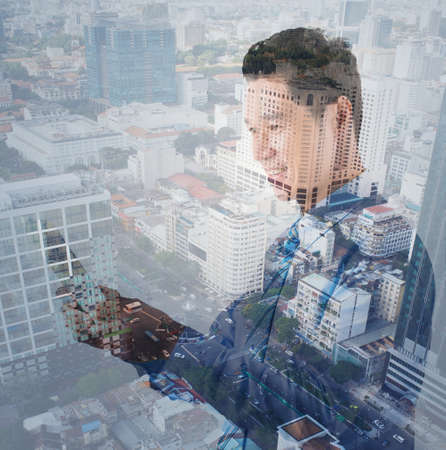 Double exposure of city and Vietnamese businessman using digital tabletの写真素材
