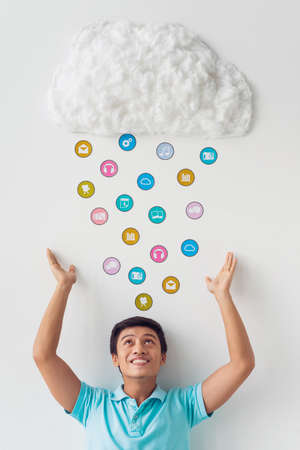 Young man storing applications in cloud storageの写真素材