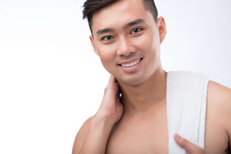 Smiling Vietnamese man after shower of workout with a towel on his shoulderの写真素材