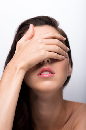 Woman covering eyes with her handの写真素材