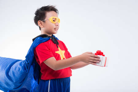 Happy boy in superhero costume giving a presentの写真素材