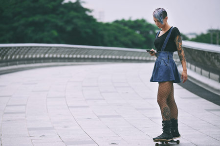 Female skater with smartphoneの写真素材