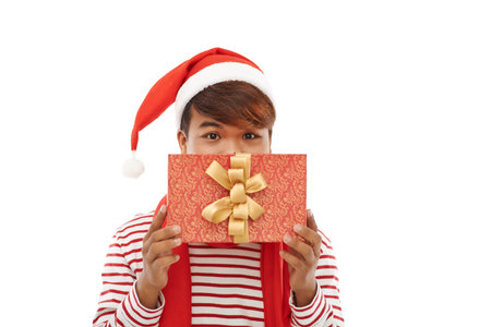 Asian man in Santa hat holding Christmas presentの写真素材