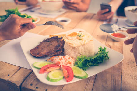 Close-up image of man eating steak with rice and vegetablesの写真素材