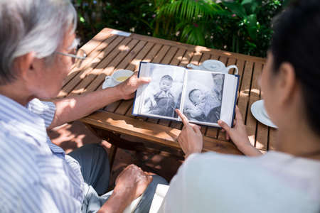 Family watching photos of little baby in the albumの写真素材