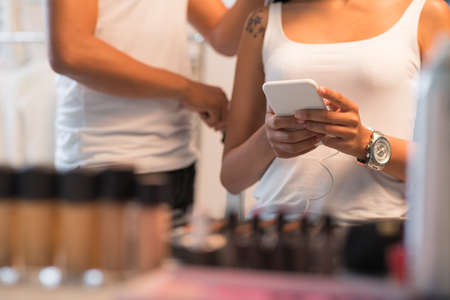 Cropped image of woman texting when sitting in beauty salonの写真素材