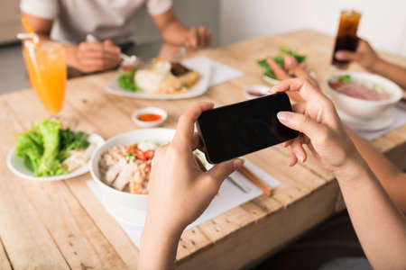 Female hands taking photo of Vietnamese pho soup before eatingの写真素材