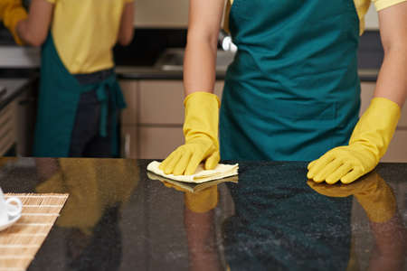 Professional cleaner wiping granite tabletop with soft clothの写真素材