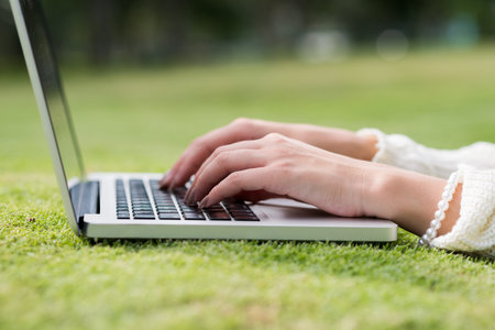 Beautiful hands of woman working on laptop outdoorsの写真素材