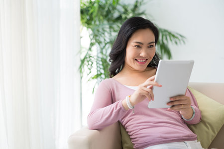 Chinese woman playing game on tablet computer